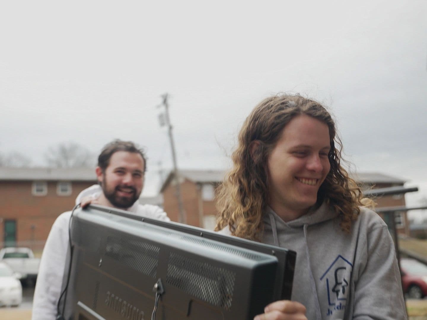Junkdrop team carrying a TV to donate