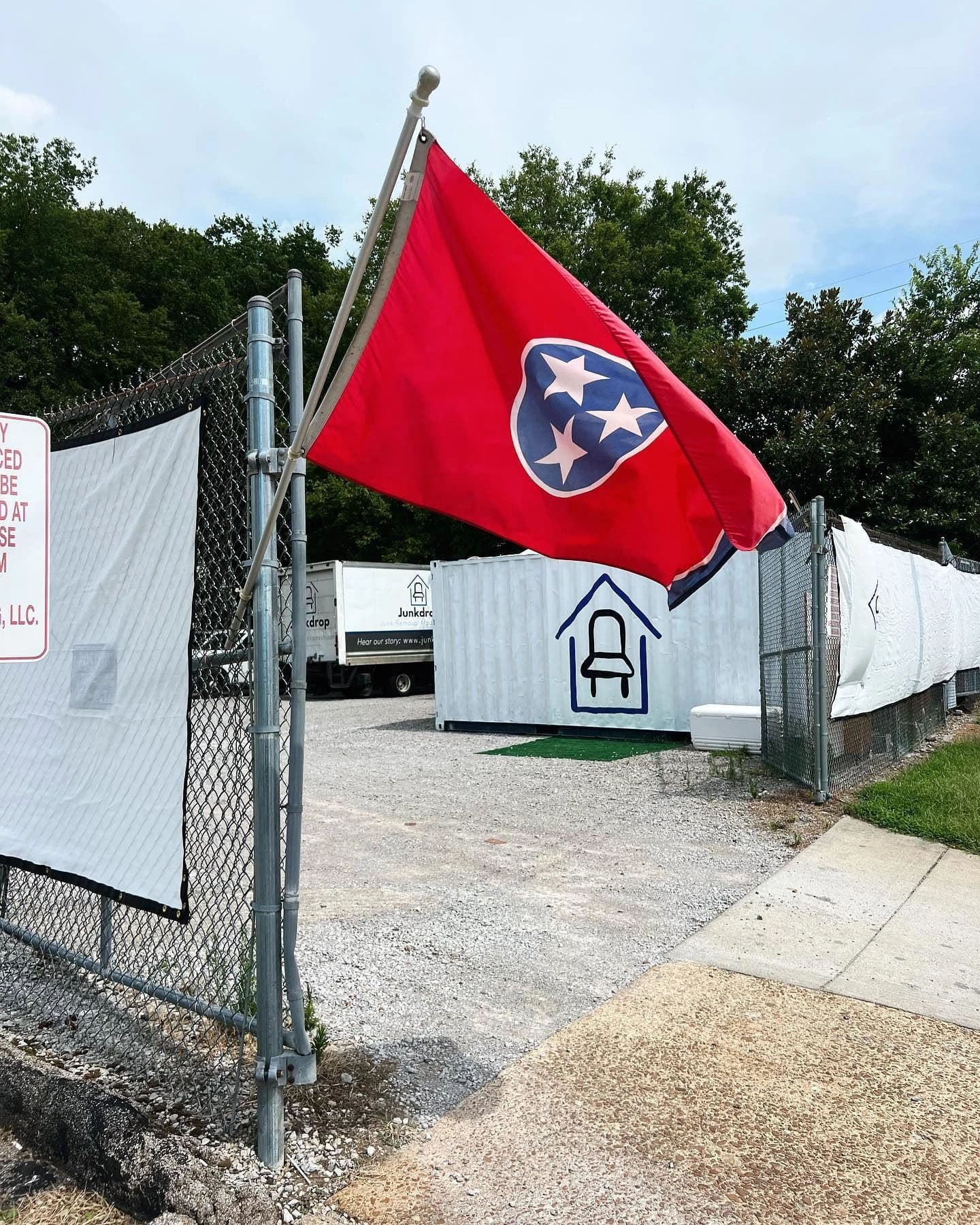 Junkdrop yard with Tennessee flag and containers