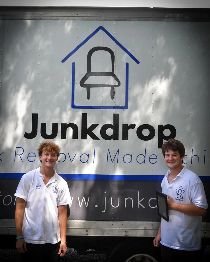 Two crew members beside a Junkdrop truck