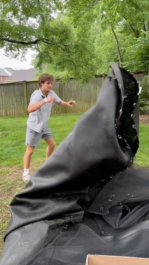 Junkdrop crew member dismantling a trampoline in a yard