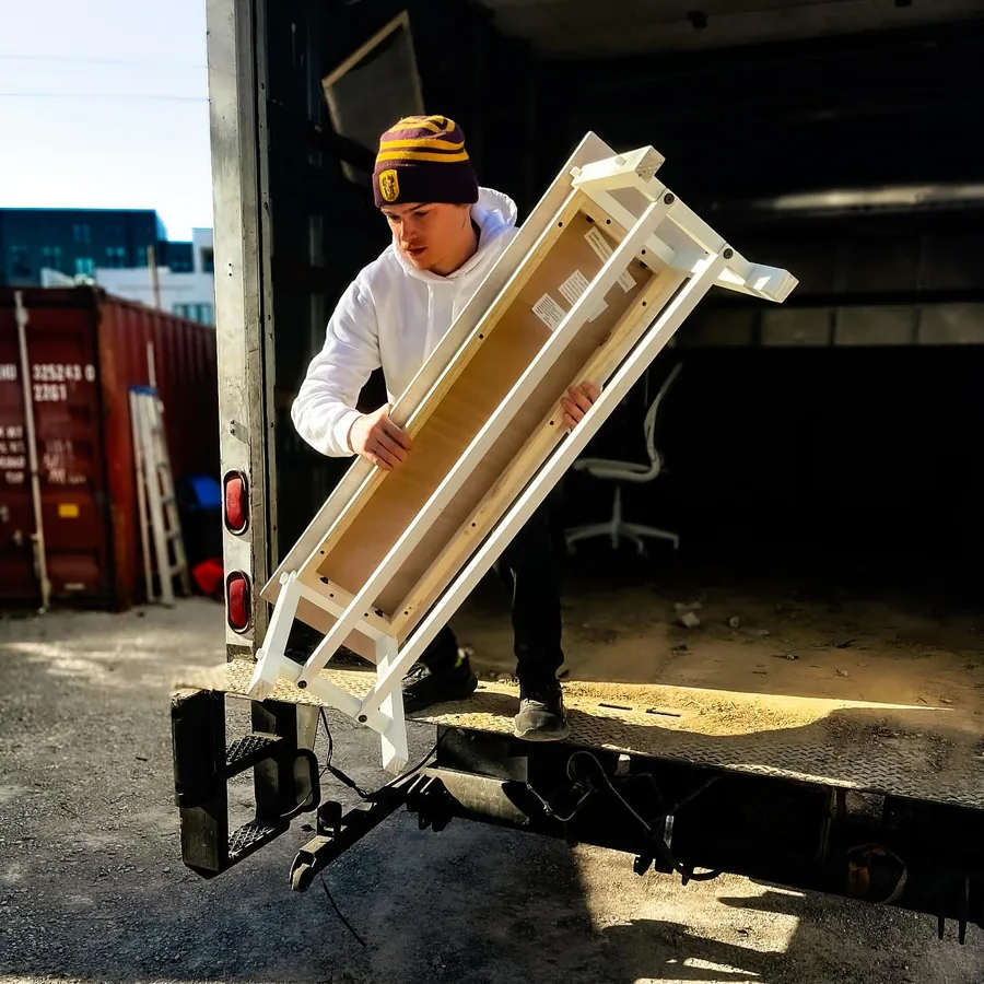 Junkdrop crew member moving furniture using a hand truck