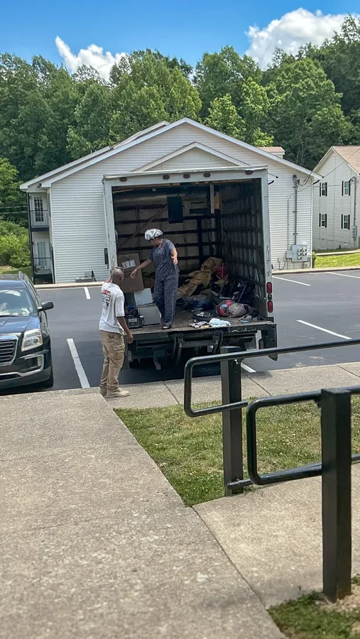 Furniture and crew outside an open garage during a Junkdrop pickup